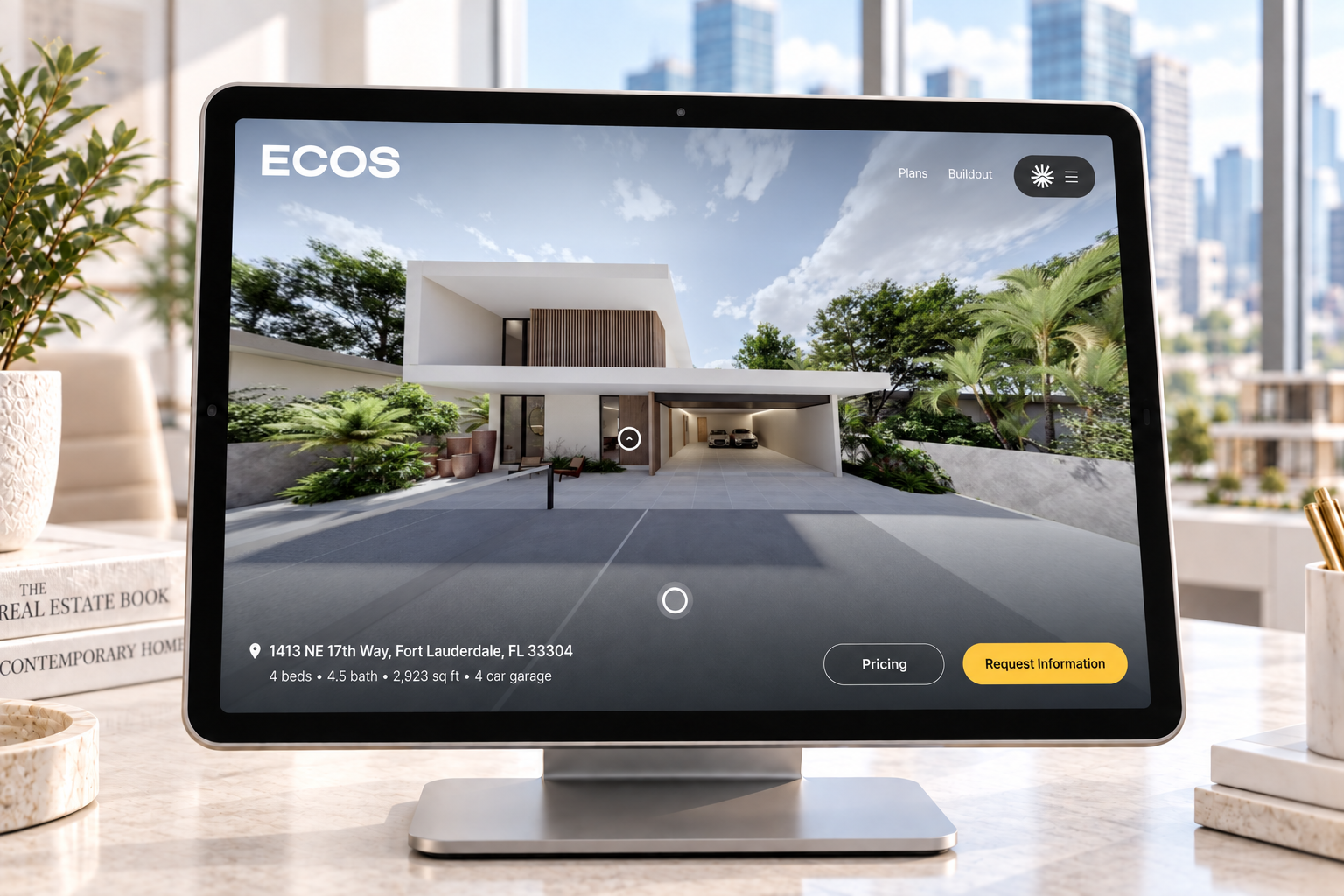 ECOS property tour displayed on a desktop monitor in a bright real estate office overlooking city buildings